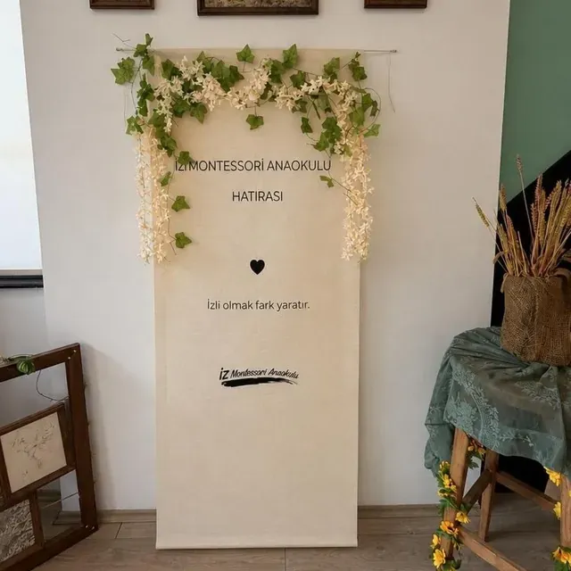 Portfolyo günü panosu: sarmaşıkla çevrili keten pano ve üstünde üç çerçeveli tablo